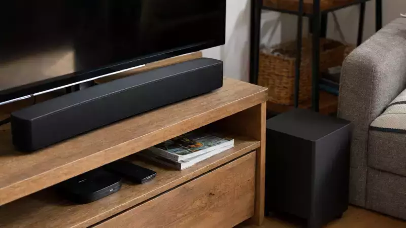 Barre de son avec caisson placée sous un téléviseur dans un salon