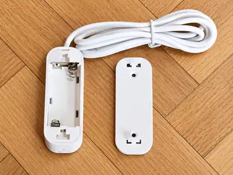 Compartiment à piles du Tuya ZG-109TDS ouvert sur un parquet
